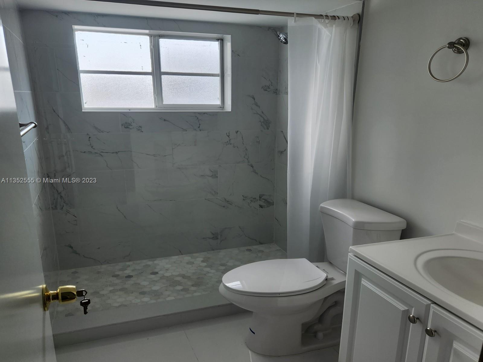 11111 Southwest 147th Court Miami, FL 33196 - Photo 15 of 20 a bathroom with a toilet sink a window and shower