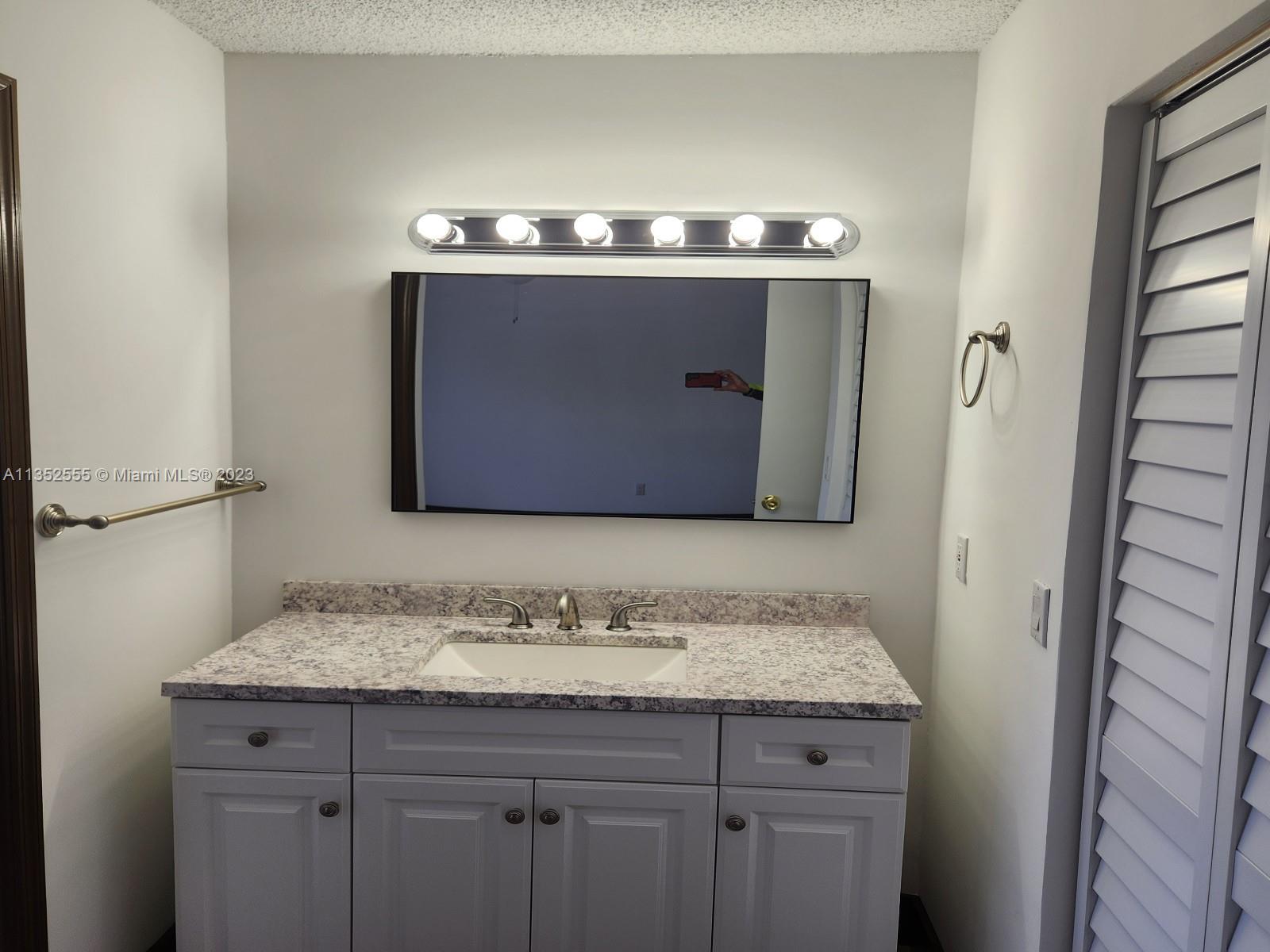 11111 Southwest 147th Court Miami, FL 33196 - Photo 18 of 20 a bathroom with a granite countertop sink a toilet and a mirror