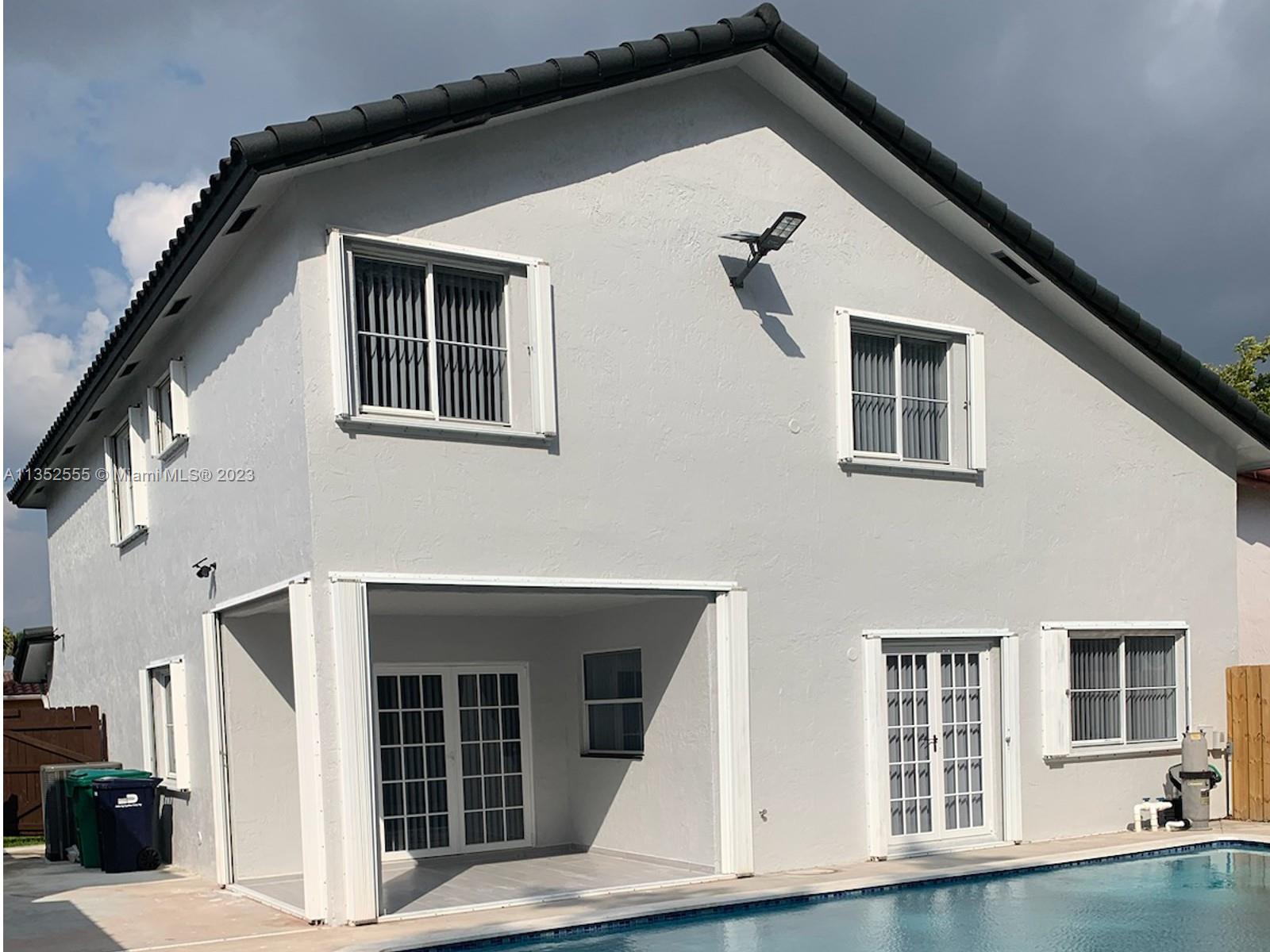 11111 Southwest 147th Court Miami, FL 33196 - Photo 2 of 20 a front view of a house with large windows