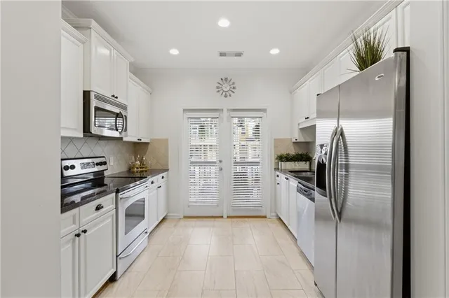a kitchen with granite countertop a refrigerator stove and oven