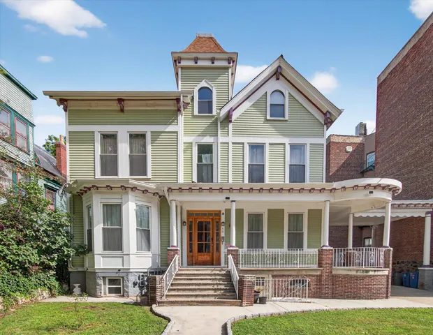 a front view of residential houses with yard and green space