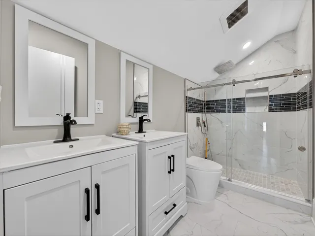 a view of bathroom with a sink mirror toilet and shower