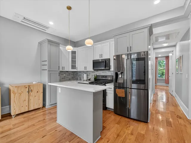 a kitchen with stainless steel appliances a refrigerator and a stove top oven