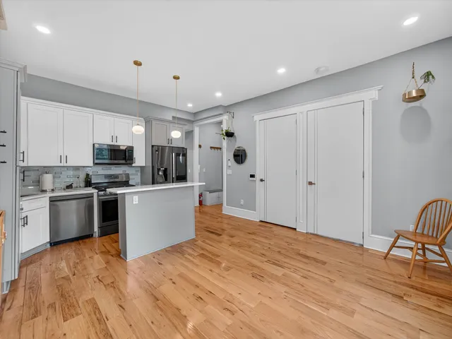 a kitchen with granite countertop a refrigerator stove top oven and sink