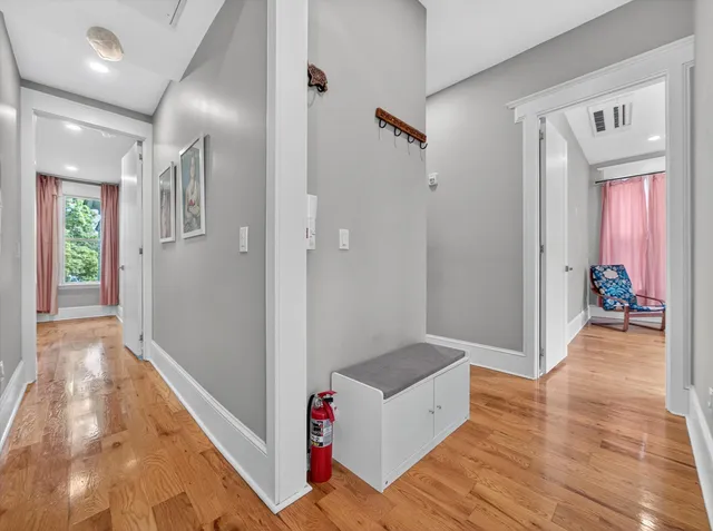 a view of a hallway with wooden floor and furniture
