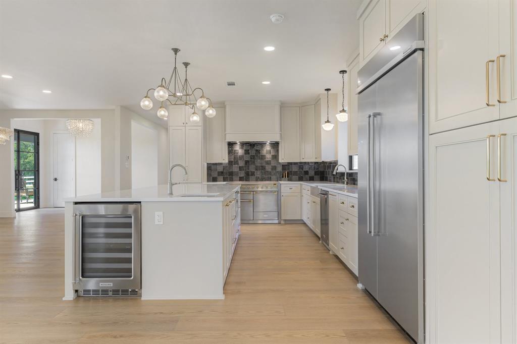 1040 Brush Creek Road Argyle, TX 76226 - Photo 13 of 40 a kitchen with white cabinets and stainless steel appliances