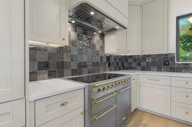 a kitchen with a stove cabinets and wooden floor