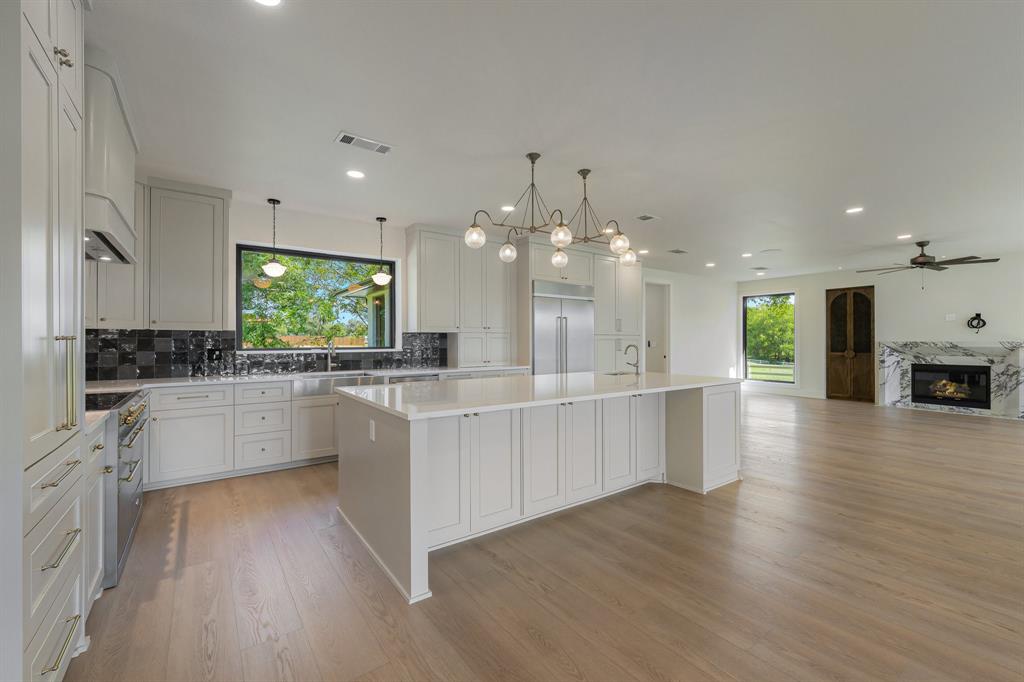 1040 Brush Creek Road Argyle, TX 76226 - Photo 39 of 40 a large kitchen with kitchen island a sink a center island stainless steel appliances and a counter space