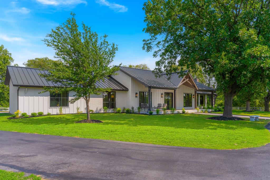 1040 Brush Creek Road Argyle, TX 76226 - Photo 2 of 40 a front view of a house with a garden and trees