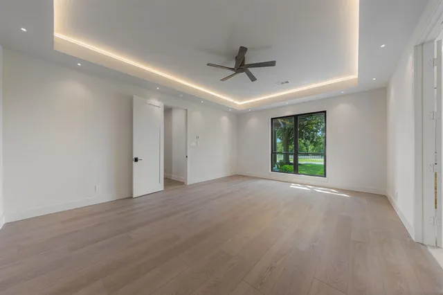 a large white kitchen with kitchen island a large counter top a stove and a chandelier
