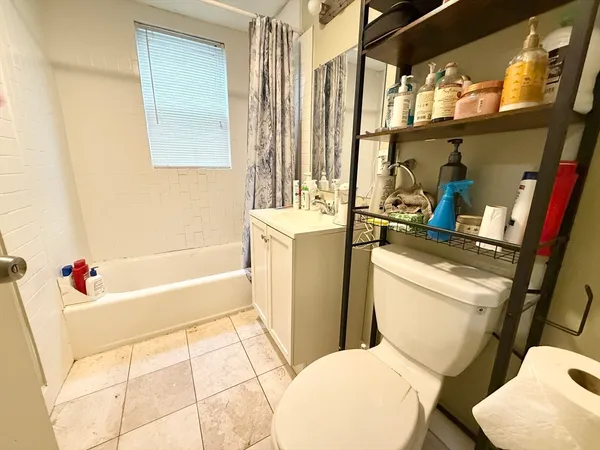 a white toilet sitting next to a bathroom sink and tub