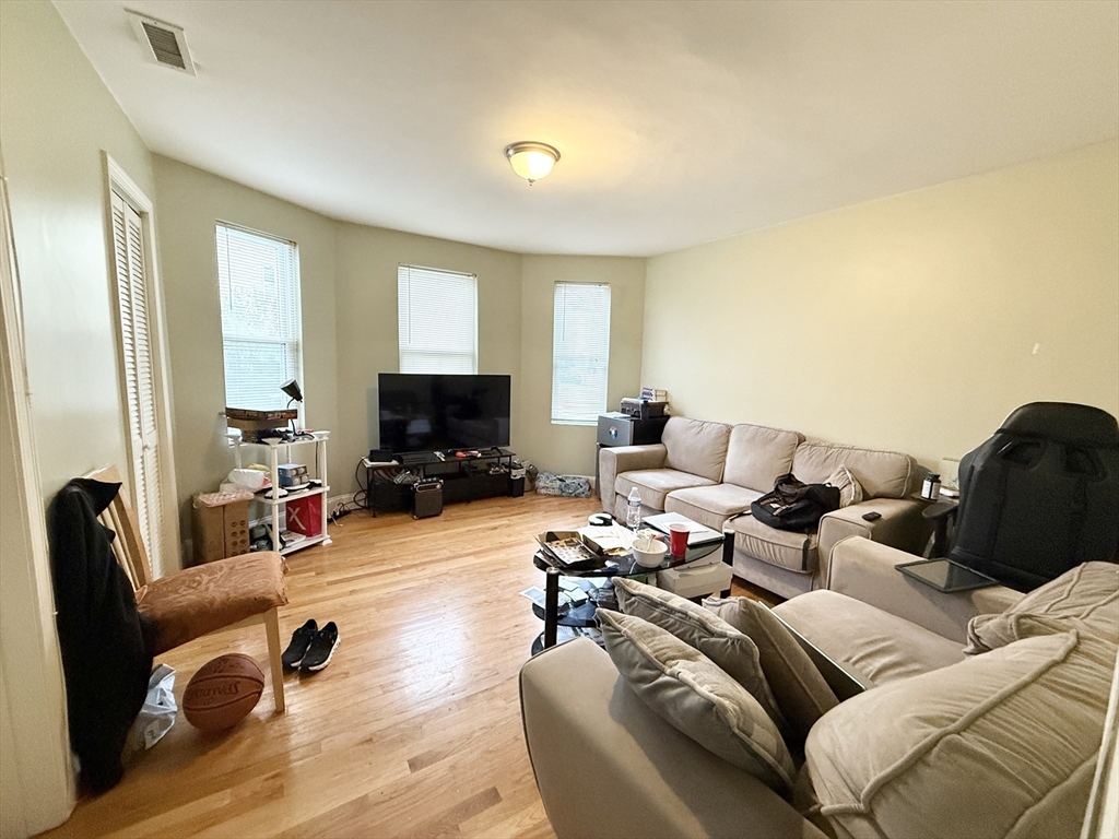 3977 Washington Street, Unit 1 Boston, MA 02131 - Photo 5 of 13 a living room with furniture and a flat screen tv