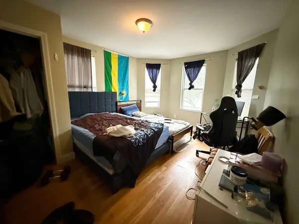 a bedroom with a bed and wooden floor