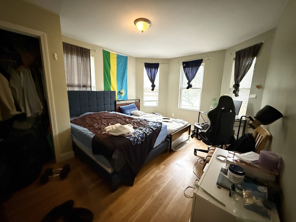 3977 Washington Street, Unit 1 Boston, MA 02131 - Photo 7 of 13 a bedroom with a bed and wooden floor