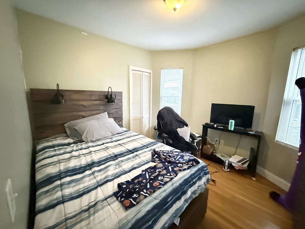 3977 Washington Street, Unit 1 Boston, MA 02131 - Photo 8 of 13 a bedroom with a bed and a chair