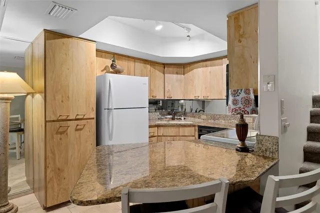 a kitchen with kitchen island granite countertop a sink a counter top space and cabinets