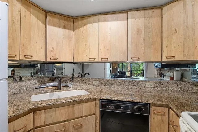 a kitchen with granite countertop a stove sink and microwave
