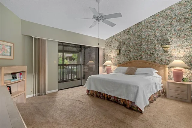 a bedroom with a bed large window and a flat tv screen