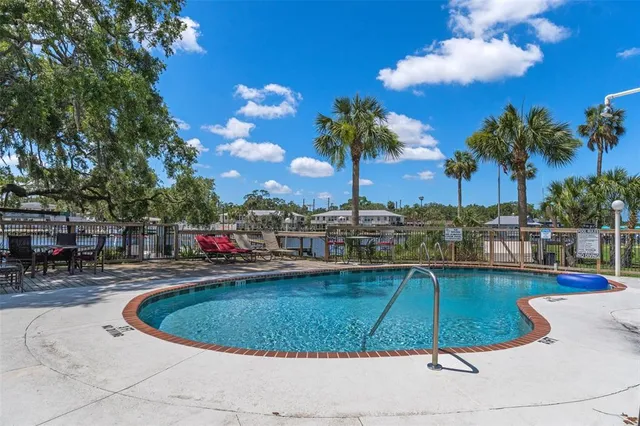 a view of a swimming pool with a patio and a yard