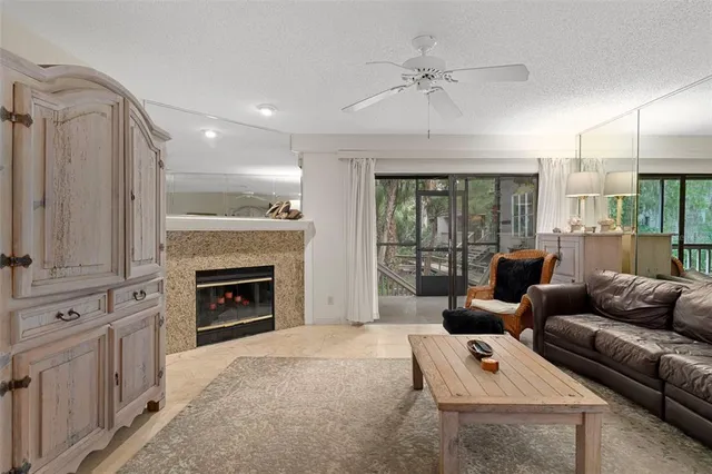 a living room with furniture a fireplace and a floor to ceiling window