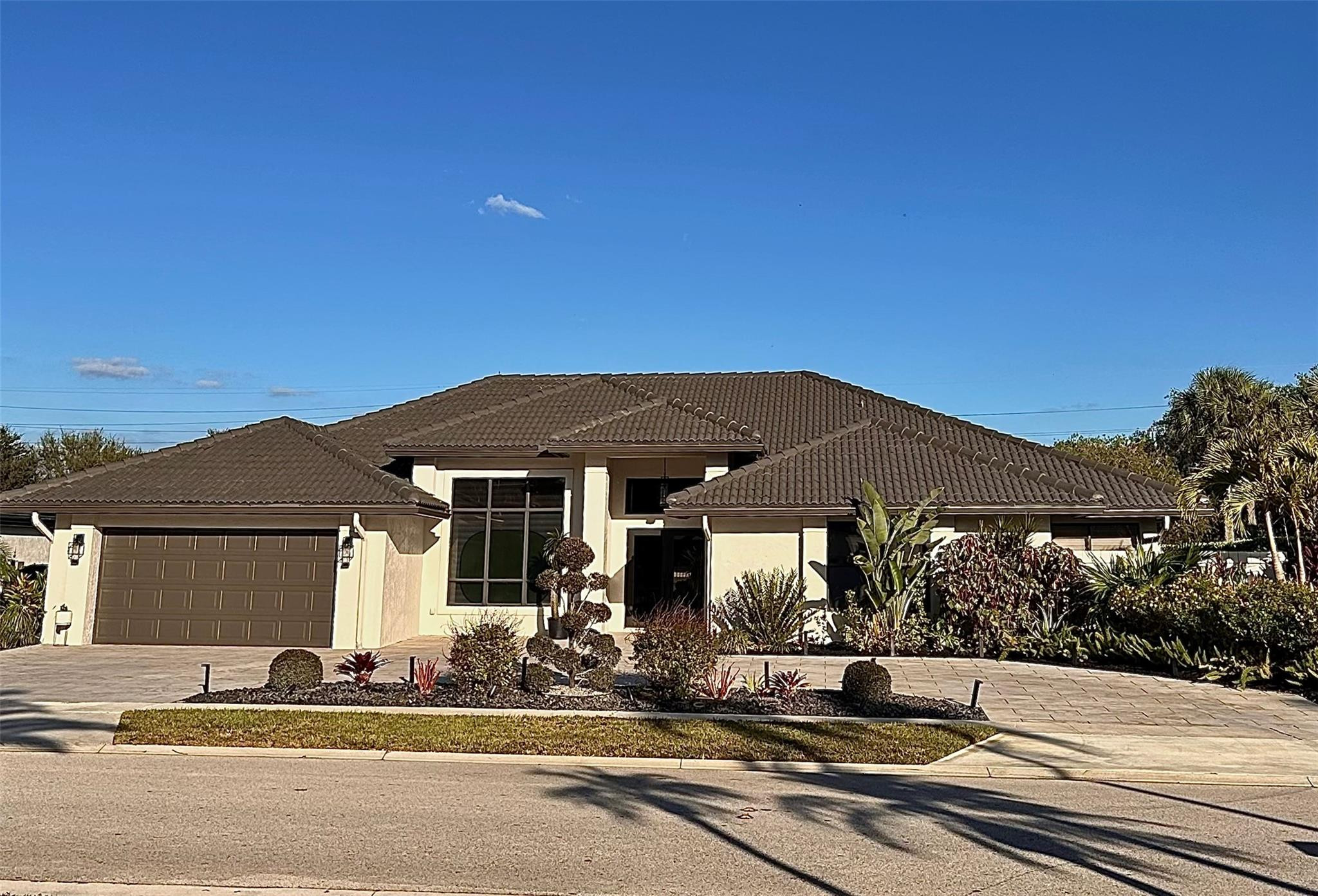 11392 Boca Woods Lane Boca Raton, FL 33428 - Photo 1 of 26 a front view of a house with a garden