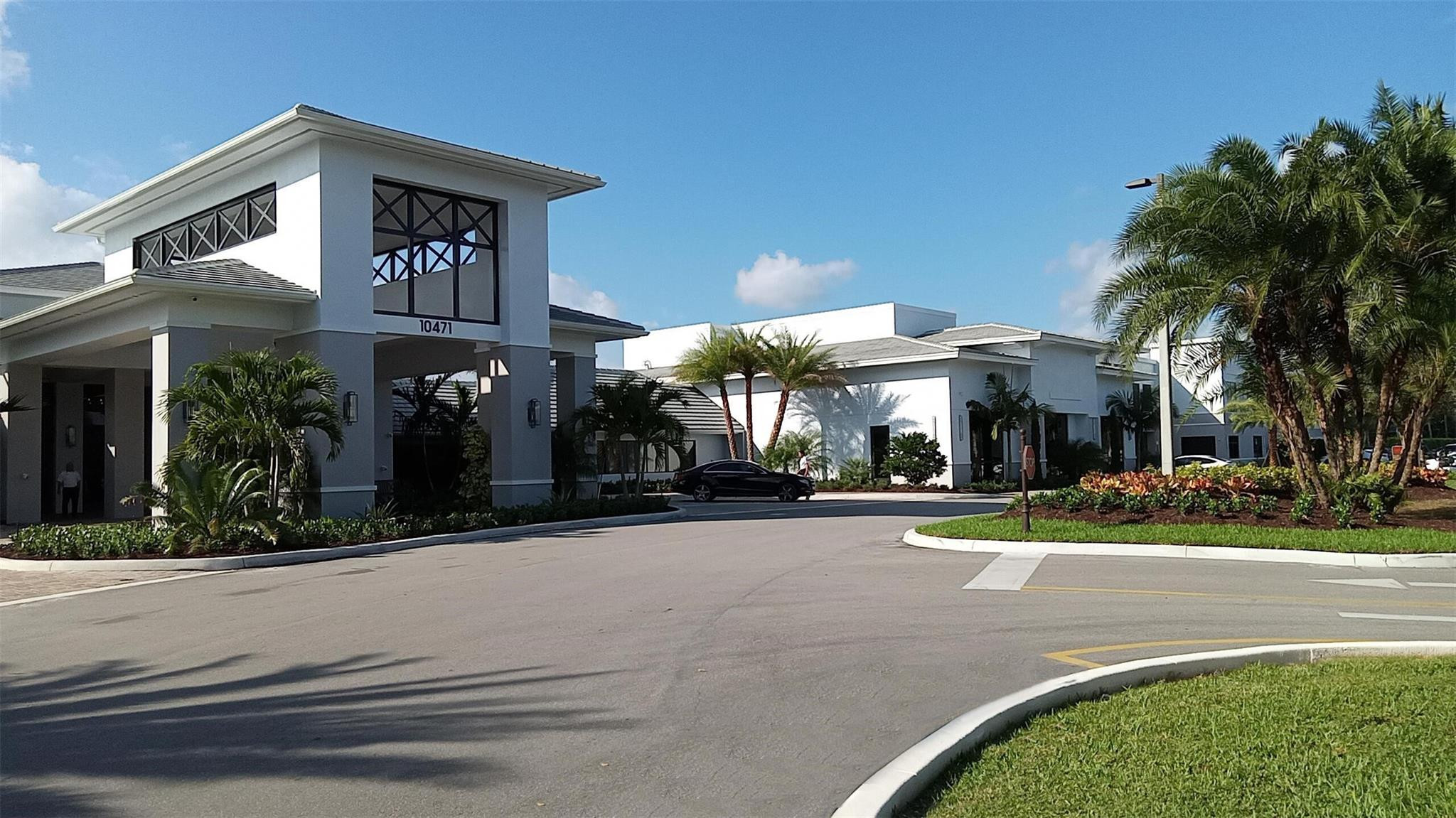 11392 Boca Woods Lane Boca Raton, FL 33428 - Photo 23 of 26 a front view of a house with a yard and potted plants
