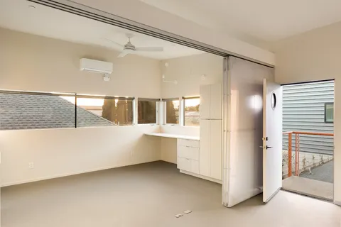 a view of a house with plants and wooden fence