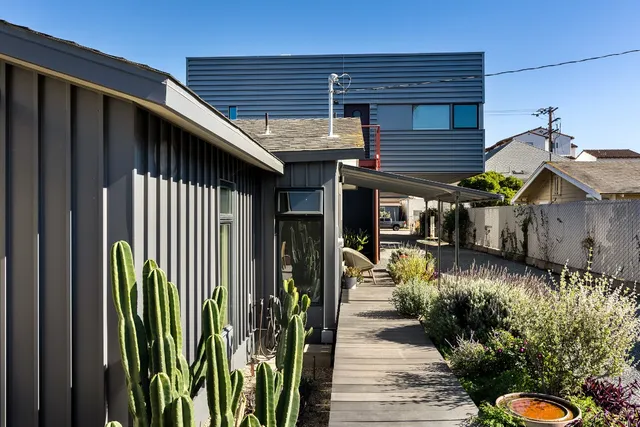 a patio with table and chairs and potted plants