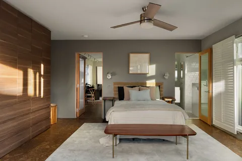 a bedroom with a bed and a large window