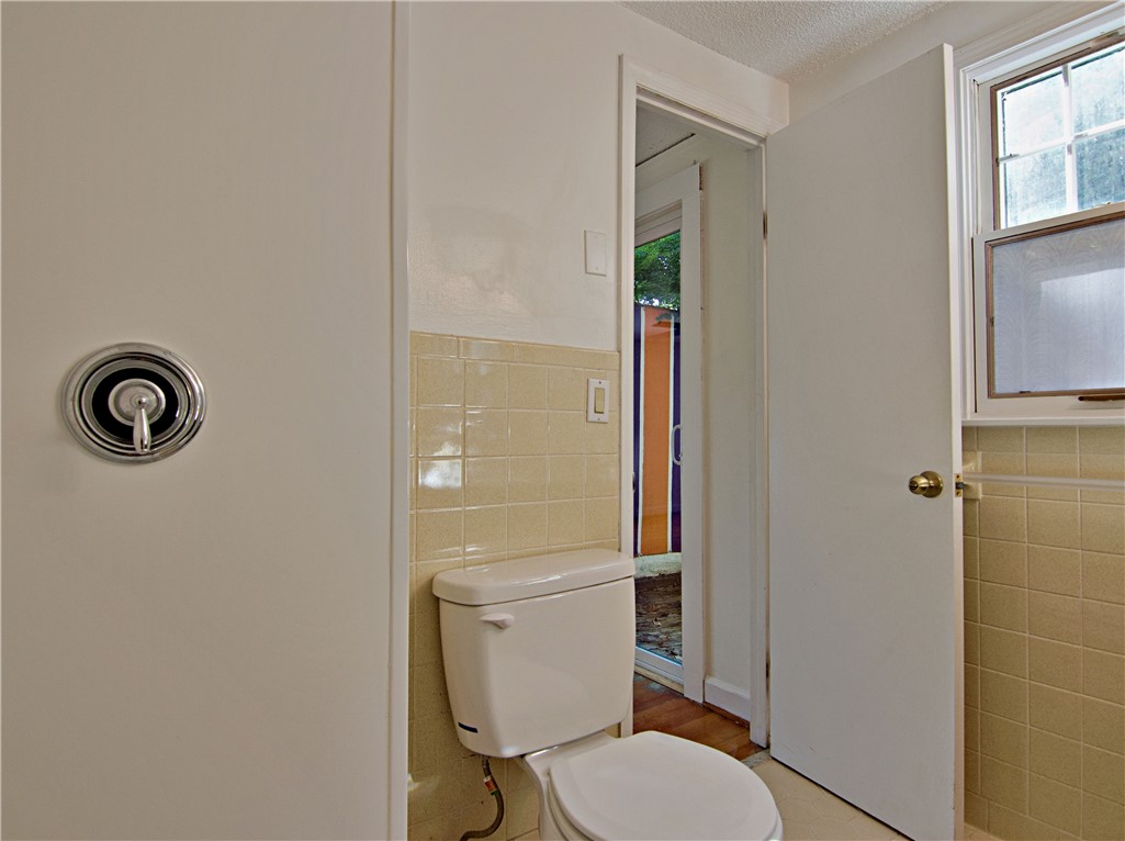102 Broad Street Clemson, SC 29631 - Photo 20 of 40 A well-maintained bathroom with a toilet and tiled walls offers practical comfort.
