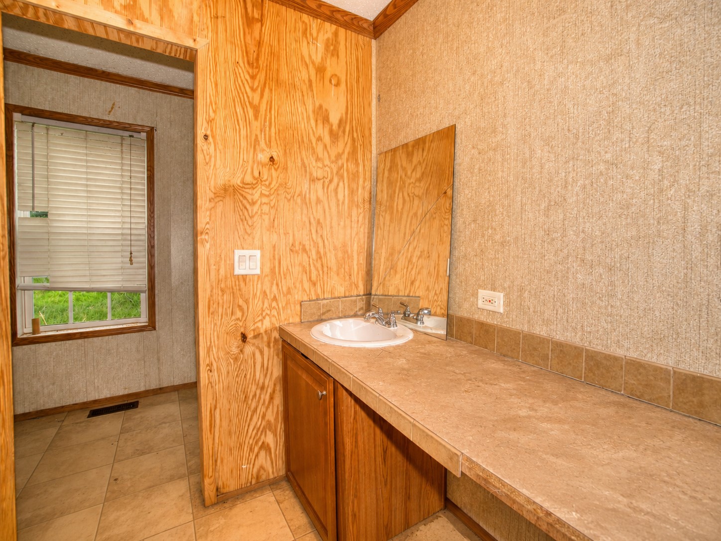 461924 East 1140 Road Sallisaw, OK 74955 - Photo 19 of 29 Built-in vanity with integrated sink, wood-finish cabinetry, tile countertop, and wood-finish wall paneling