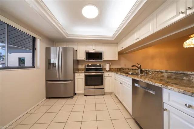 a kitchen with stainless steel appliances granite countertop a refrigerator and a stove top oven