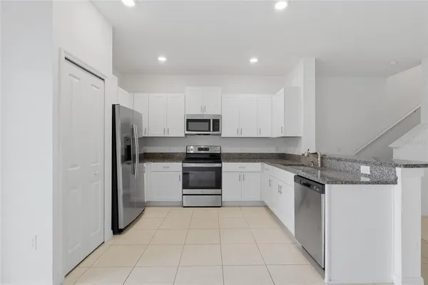 a kitchen with stainless steel appliances granite countertop a refrigerator and a sink