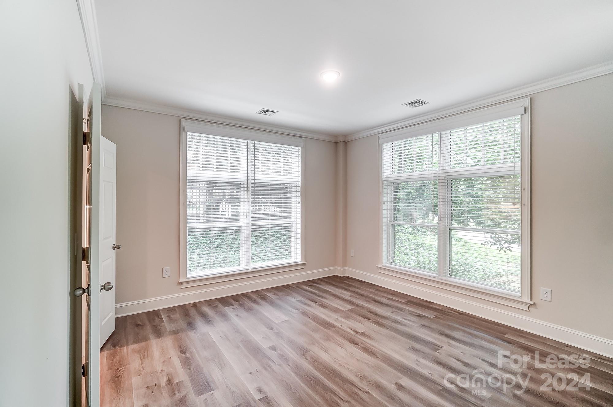 1301 Queens Road, Unit 205 Charlotte, NC 28207 - Photo 11 of 23 an empty room with wooden floor and windows