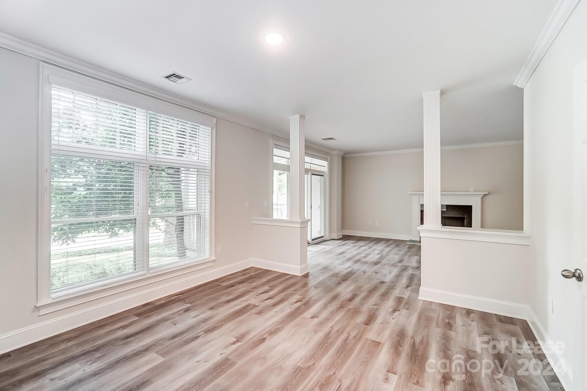 1301 Queens Road, Unit 205 Charlotte, NC 28207 - Photo 13 of 23 a view of empty room with wooden floor and fan