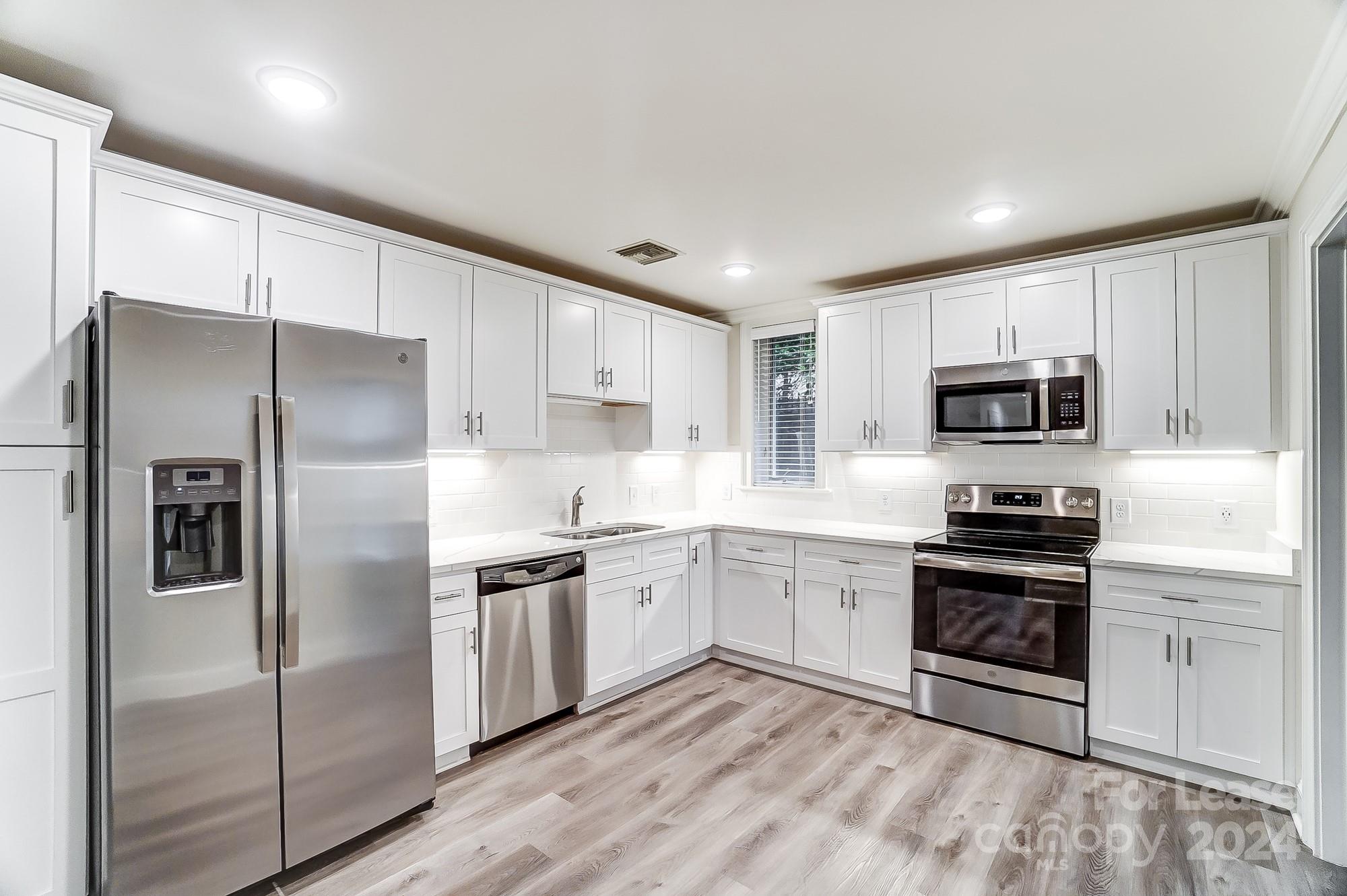 1301 Queens Road, Unit 205 Charlotte, NC 28207 - Photo 14 of 23 a kitchen with stainless steel appliances granite countertop a stove a refrigerator and a sink