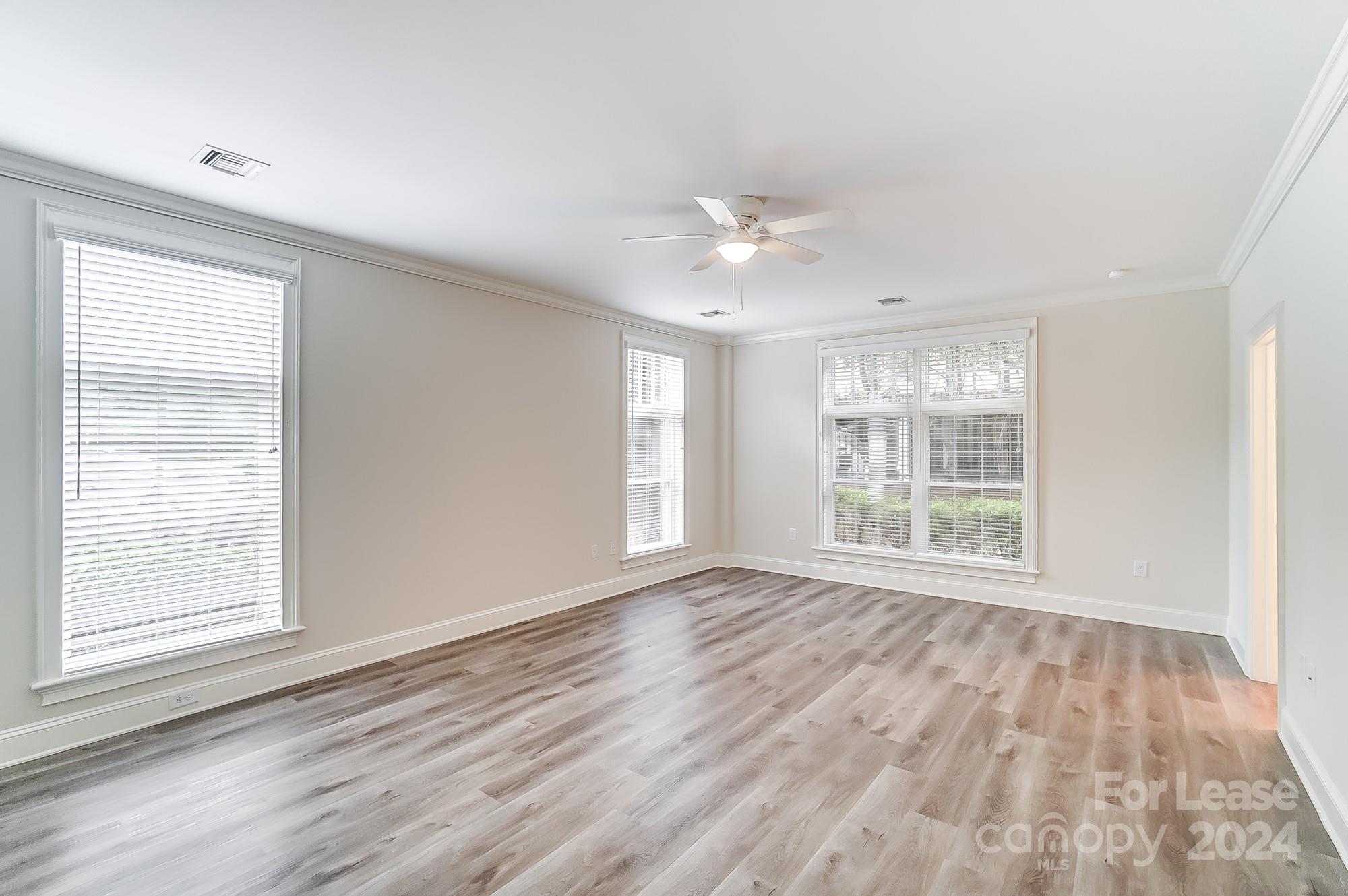 1301 Queens Road, Unit 205 Charlotte, NC 28207 - Photo 18 of 23 a view of an empty room with wooden floor and a window