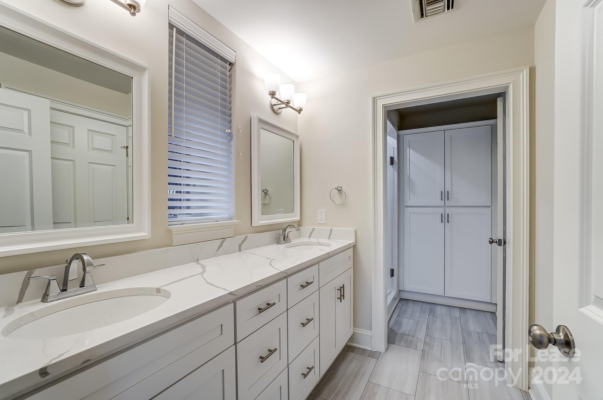 1301 Queens Road, Unit 205 Charlotte, NC 28207 - Photo 19 of 23 a bathroom with a double vanity sink and a mirror