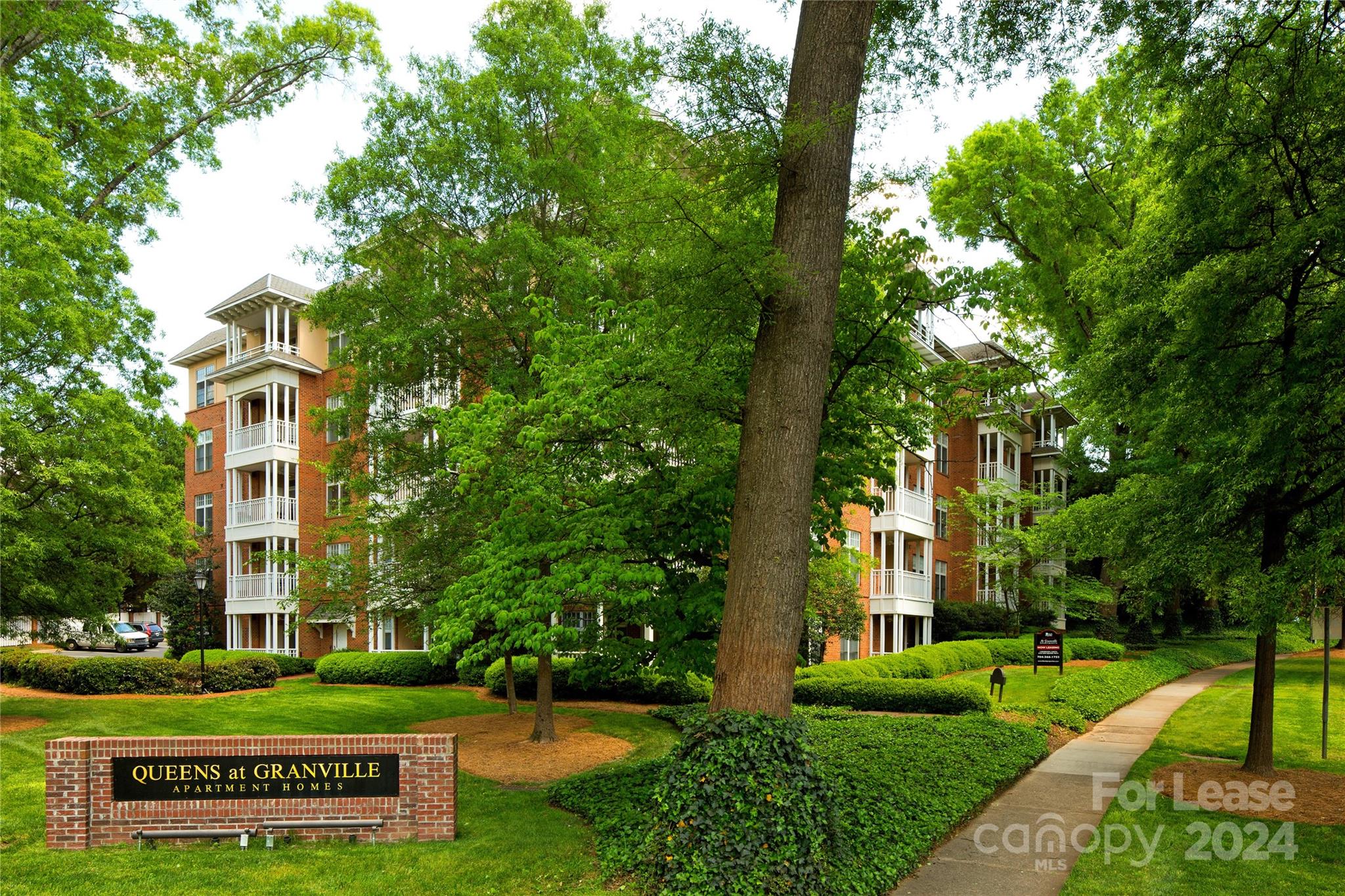 1301 Queens Road, Unit 205 Charlotte, NC 28207 - Photo 2 of 23 a front view of a building with a garden