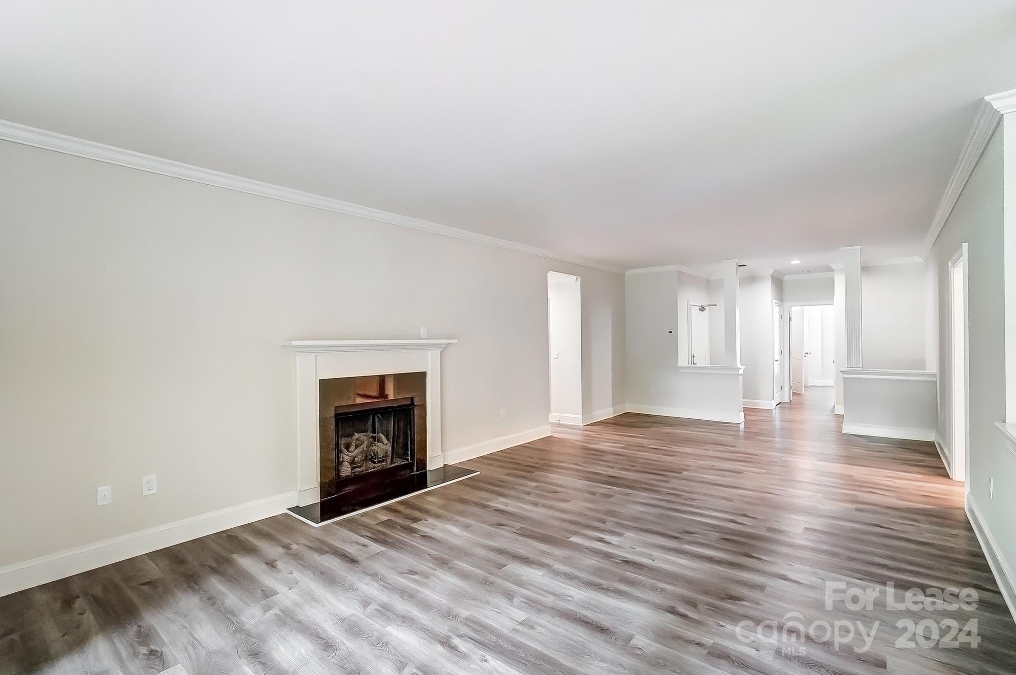 1301 Queens Road, Unit 205 Charlotte, NC 28207 - Photo 9 of 23 a view of an empty room with wooden floor fireplace and a window