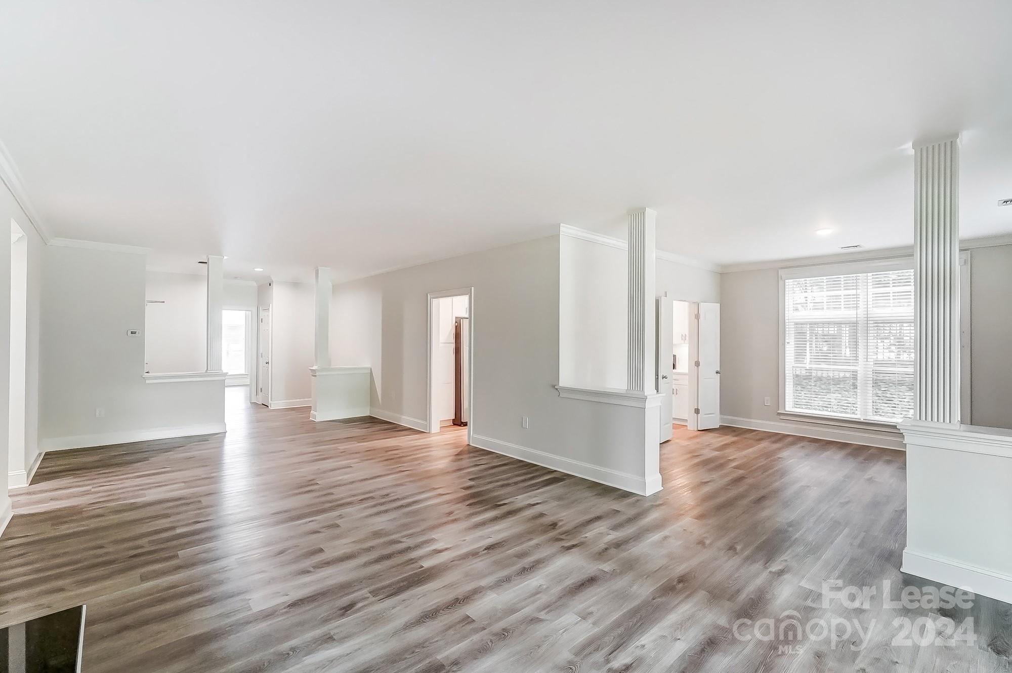 1301 Queens Road, Unit 205 Charlotte, NC 28207 - Photo 10 of 23 a view of an empty room with wooden floor and a window