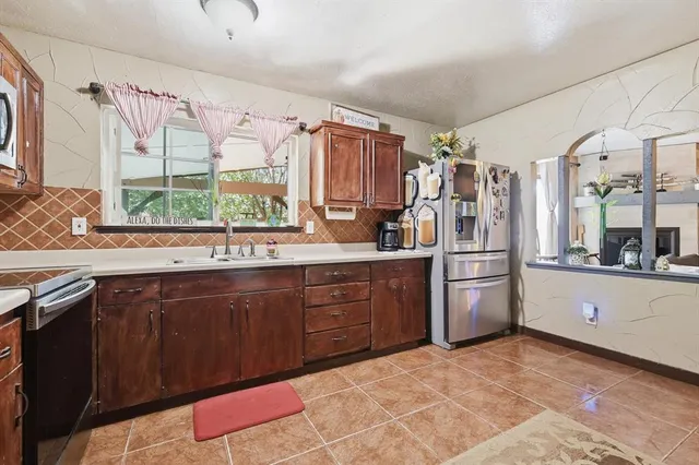 a kitchen with stainless steel appliances granite countertop a refrigerator and sink