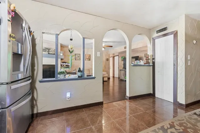 a view of a kitchen with refrigerator and wooden floor