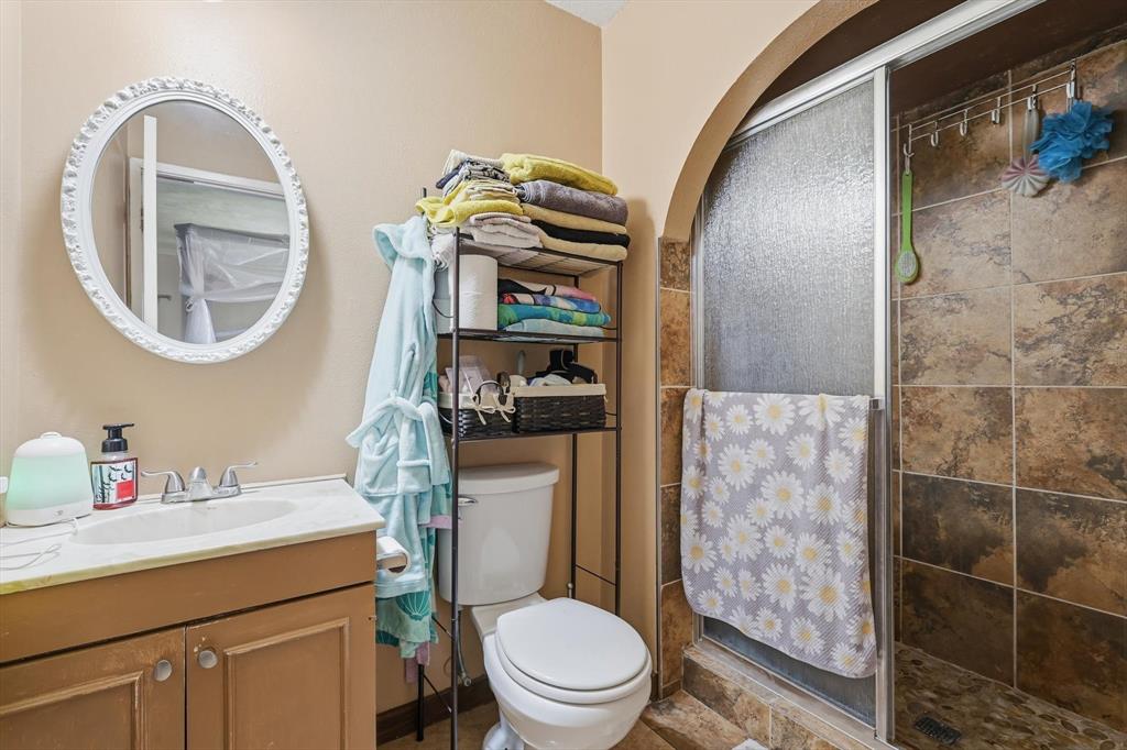 6317 Locust Street Rowlett, TX 75089 - Photo 19 of 40 a bathroom with a toilet a sink and a mirror