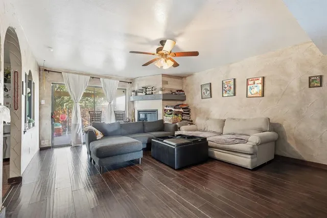 a living room with furniture wooden floor and a large window