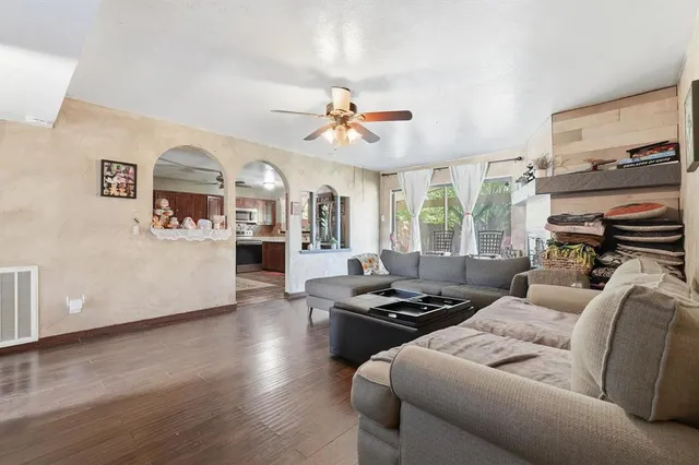a living room with furniture kitchen view and a window