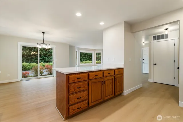 a kitchen with stainless steel appliances granite countertop a stove a sink and a refrigerator with wooden floor