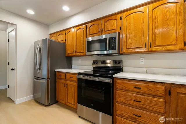 a kitchen with stainless steel appliances granite countertop a refrigerator and a stove top oven