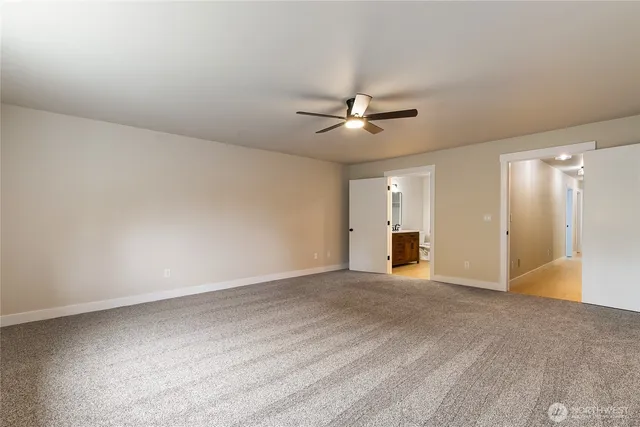 a view of an empty room with a ceiling fan