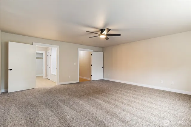 a view of an empty room with a ceiling fan